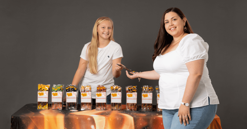 student and customer smiling after setting up fundraiser booths 