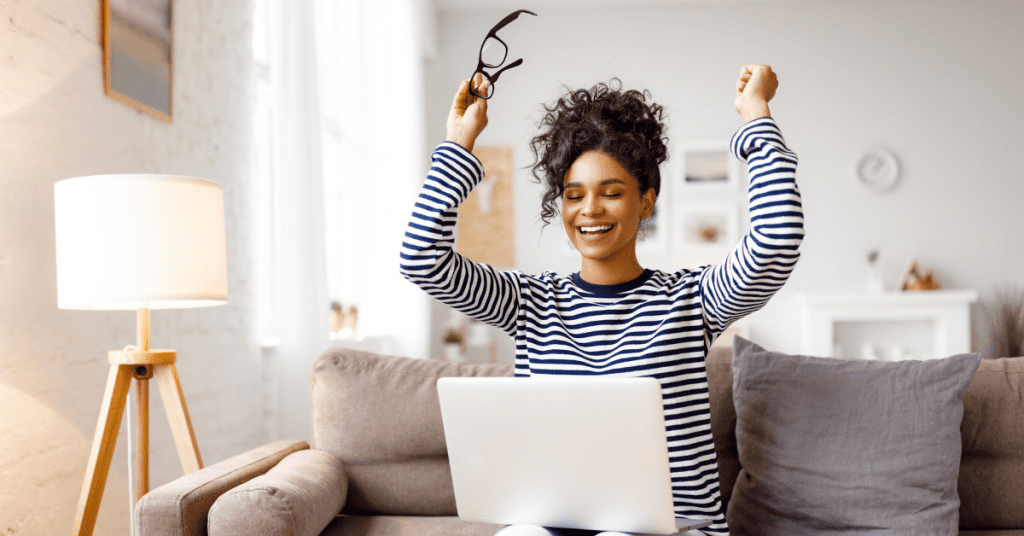 women sitting on a couch with a laptop, excited